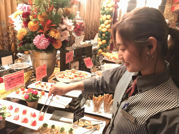 ビュッフェ台に並ぶお洒落な料理を管理。