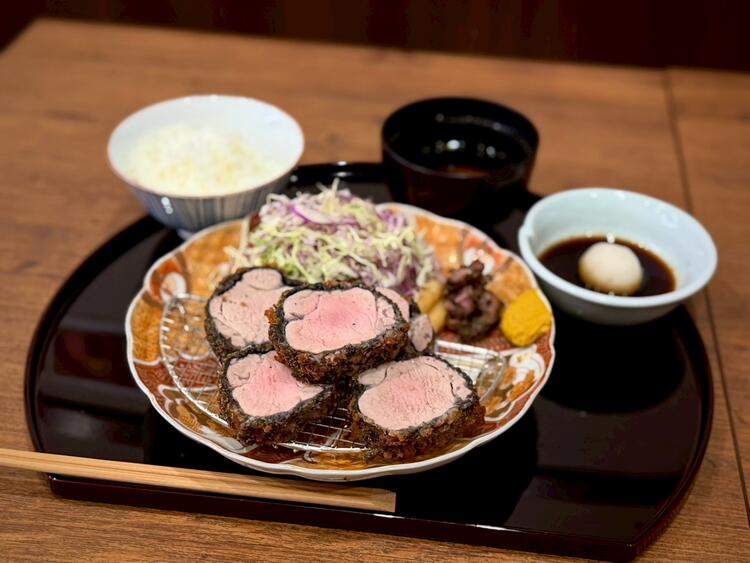 黒の衣が名物のとんかつ屋を目指す。