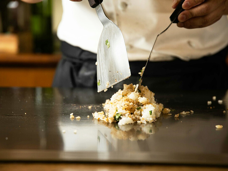 鉄板で一品一品丁寧に仕上げる料理を提供