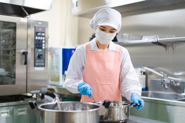 仕事する女性の給食調理員
